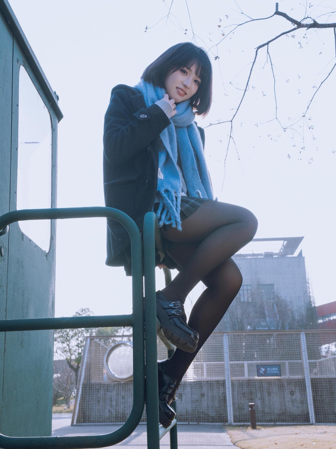 冬日暖阳下，少女倚靠栏杆，微笑如花。