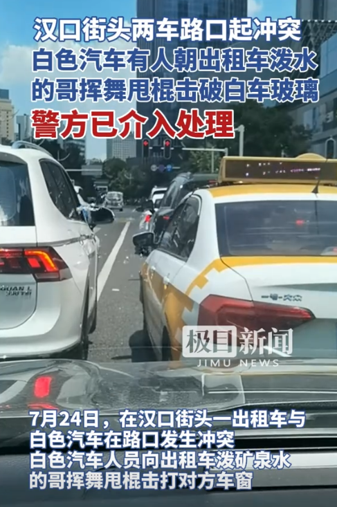 汉口街头，一辆出租车和私家车等红灯时发生冲突，私家车内有人向出租车泼水，而出租车