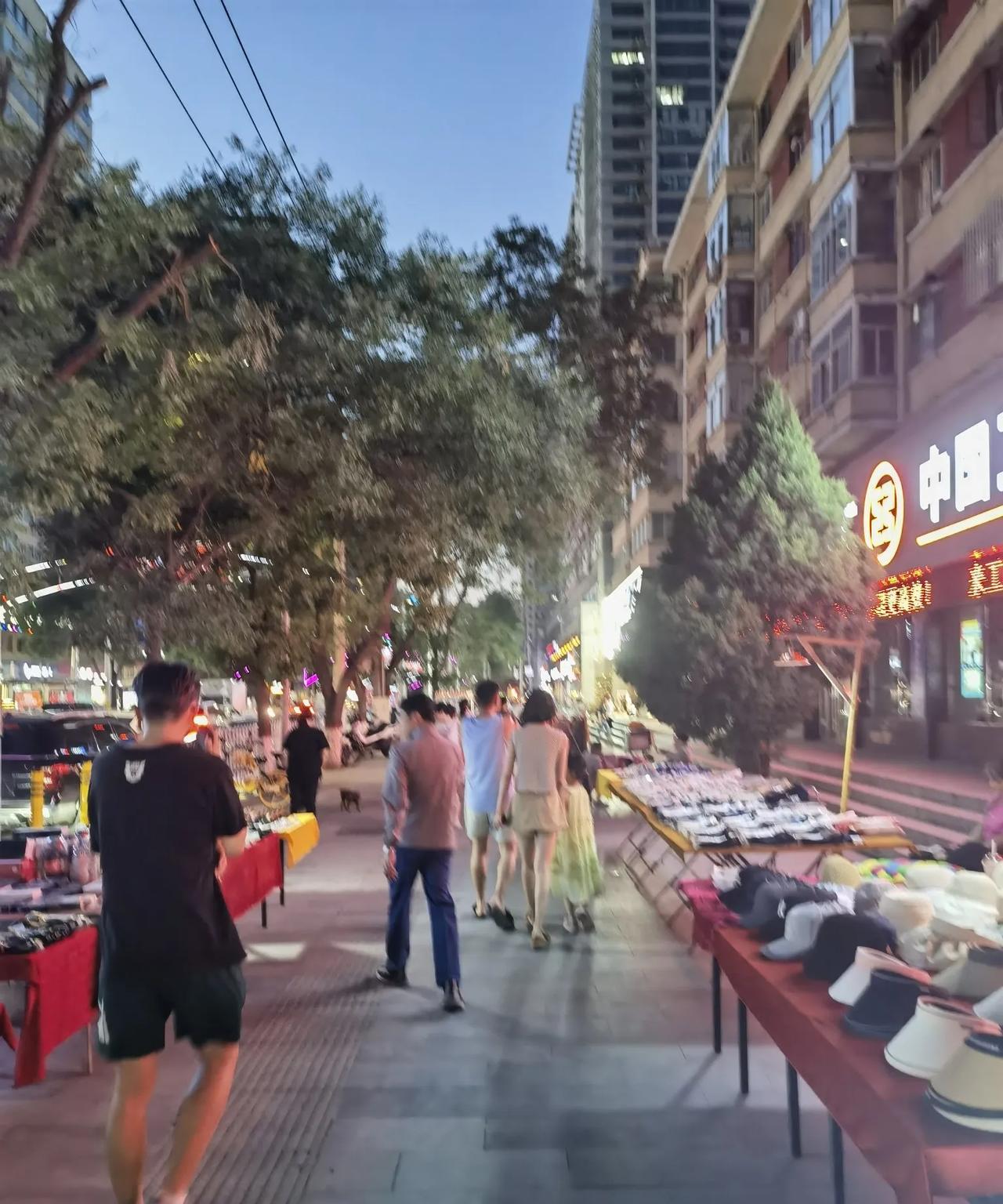 夏天的兰州，晚上9点钟了，天还没黑。皋兰路上，乘凉的人们路上的人们三三两两在漫步