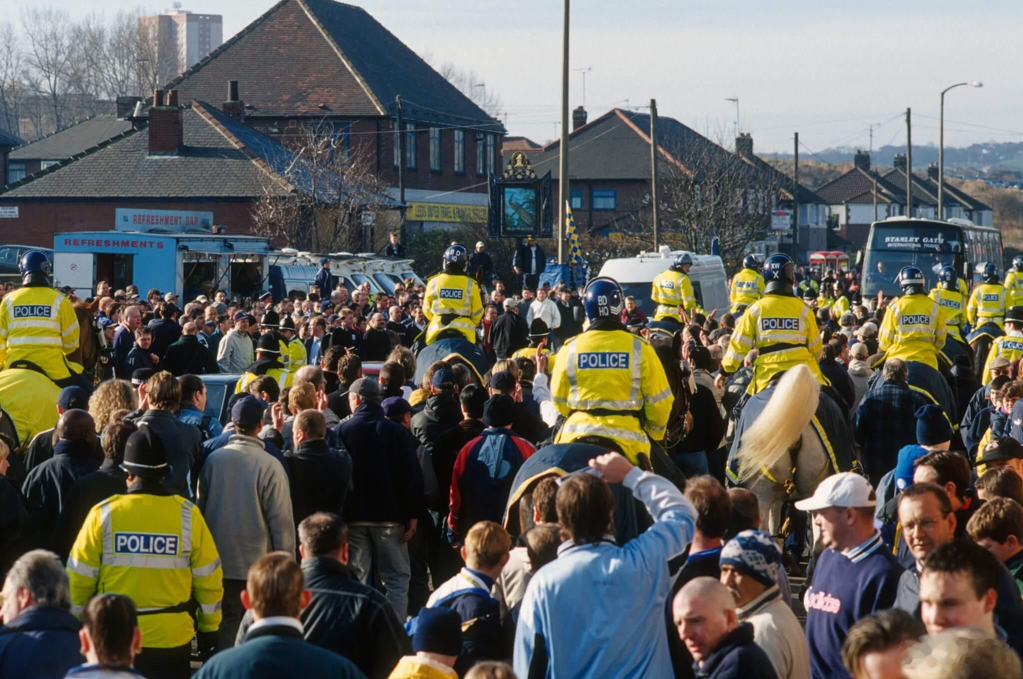 利兹联vs曼联这俩队比赛，每次都打架，从场外打到场内，警方如临大敌。曼联地处兰