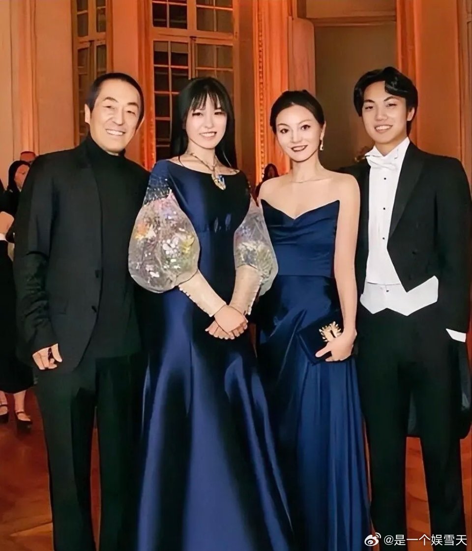 张艺谋一家四口的合影，女儿跟妈妈陈婷穿着同色系的礼服裙，身高比妈妈高，但颜值一般