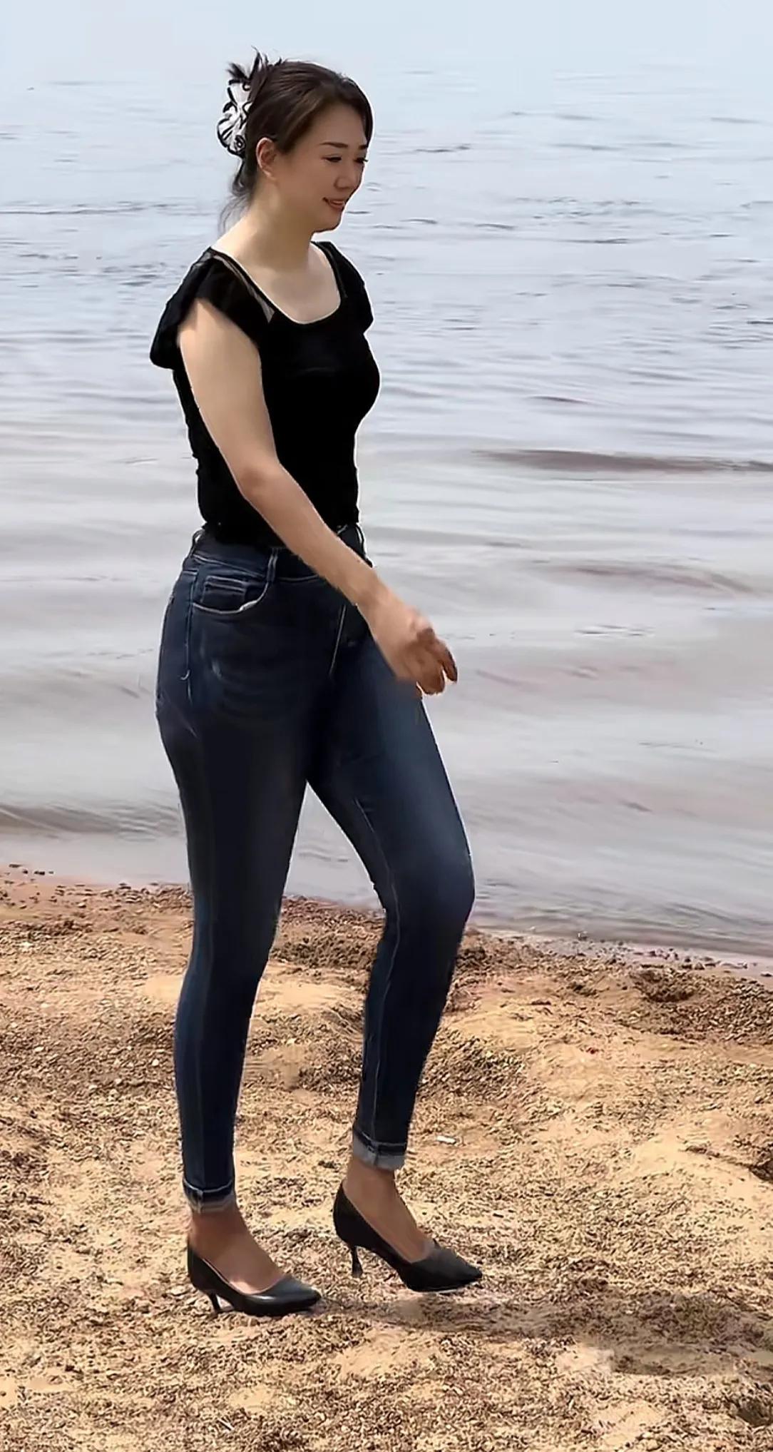 牛仔裤太酷啦！身材高挑气质出众的美女，江边漫步尽享浪漫风情。