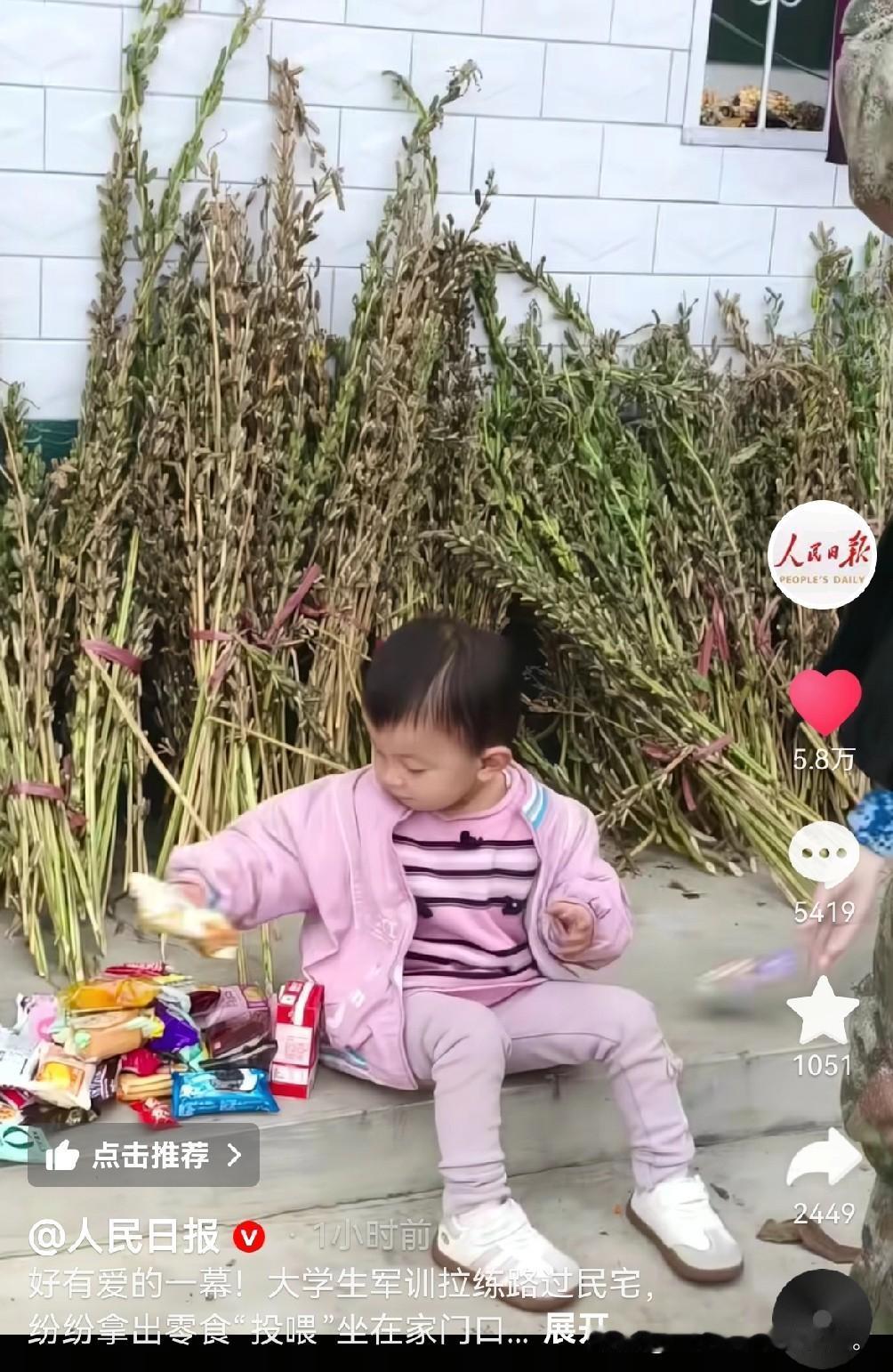 3岁小孩姐上人民日报了，3岁小孩坐在家门口被投喂，大学生送的零食吃不完根本吃