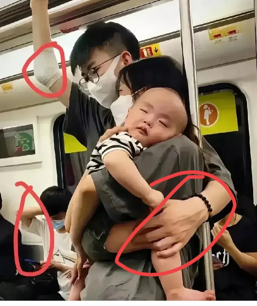 地铁上好有爱的一家人：宝宝在妈妈的肩膀上睡的很香，妈妈用地铁的扶手支撑着身体