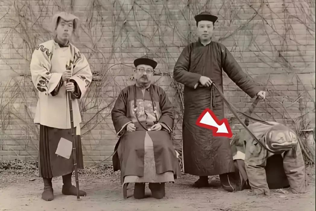 100年前的清朝贵族子弟手里竟“牵着”一个人，像动物一样趴地上，在当时又被称作“