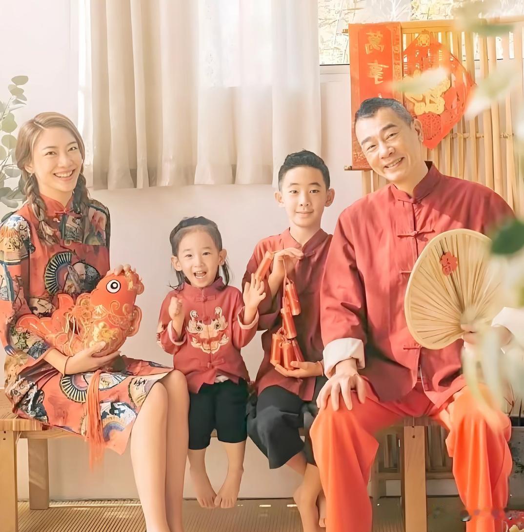 2025年，陈小春、应采儿一家四口的新春拜年全家福。陈小春一身红色唐装，手持蒲扇