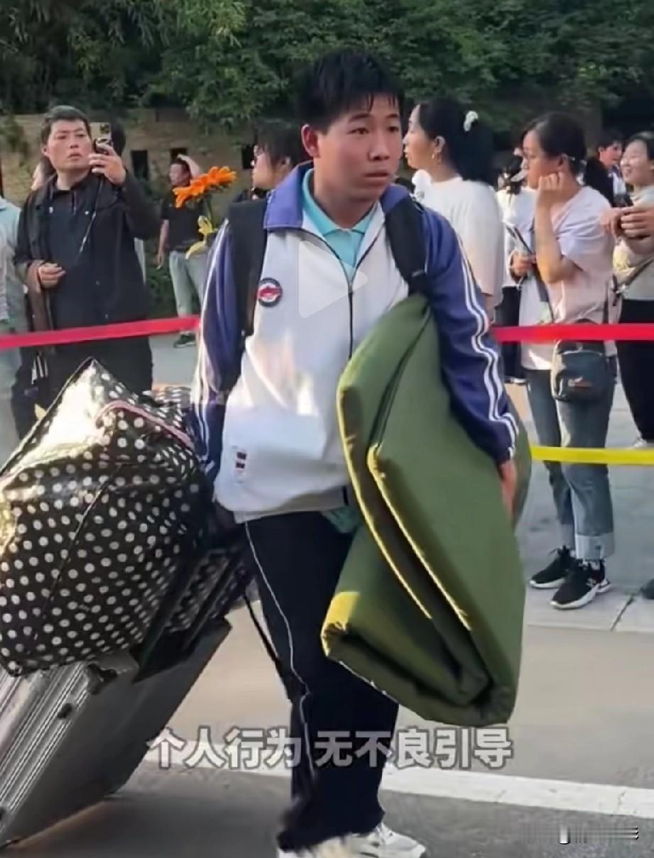 看着真是心疼。这名考生考试完毕后，自己拖着沉重的行李又出了校门，他左顾右盼，