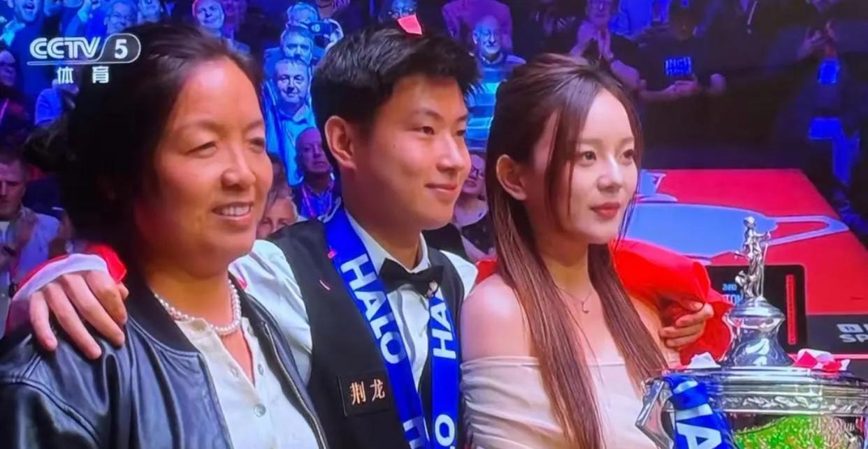 赵心童在斯诺克世锦赛夺冠夜，与女友和经纪人石圆圆在聚光灯下留下历史性合影，引发公