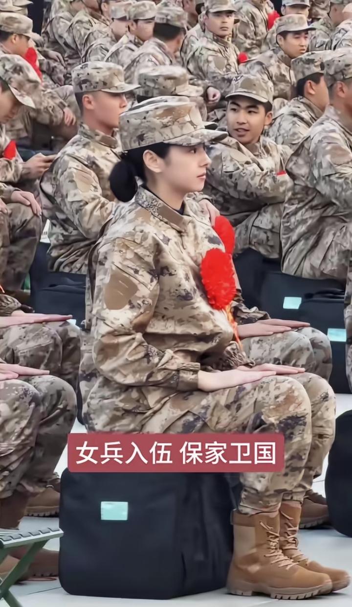 这位女兵身姿挺拔、气质出众，一身军装自带英气。坐姿端正、眼神坚定，既有少女的明媚