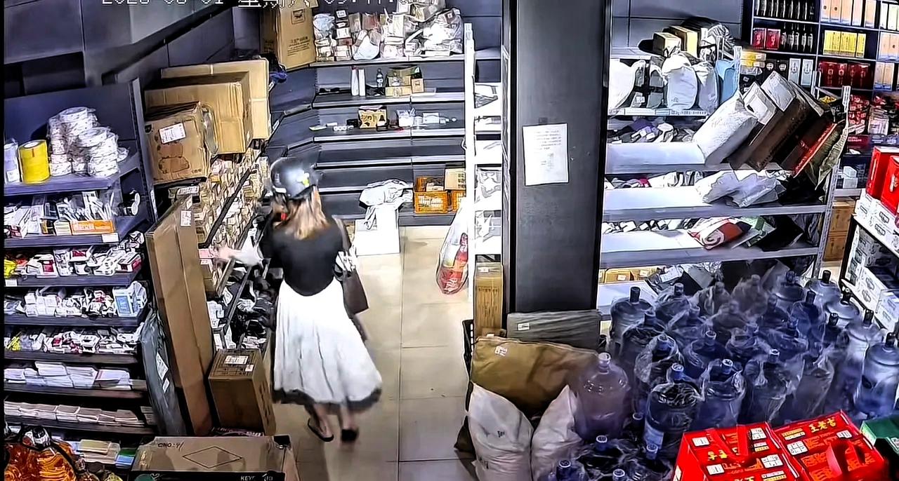 近日广东，一女子戴着头盔、口罩到驿站拿快递，女子进店后，随手就拿起货架上的快递丢
