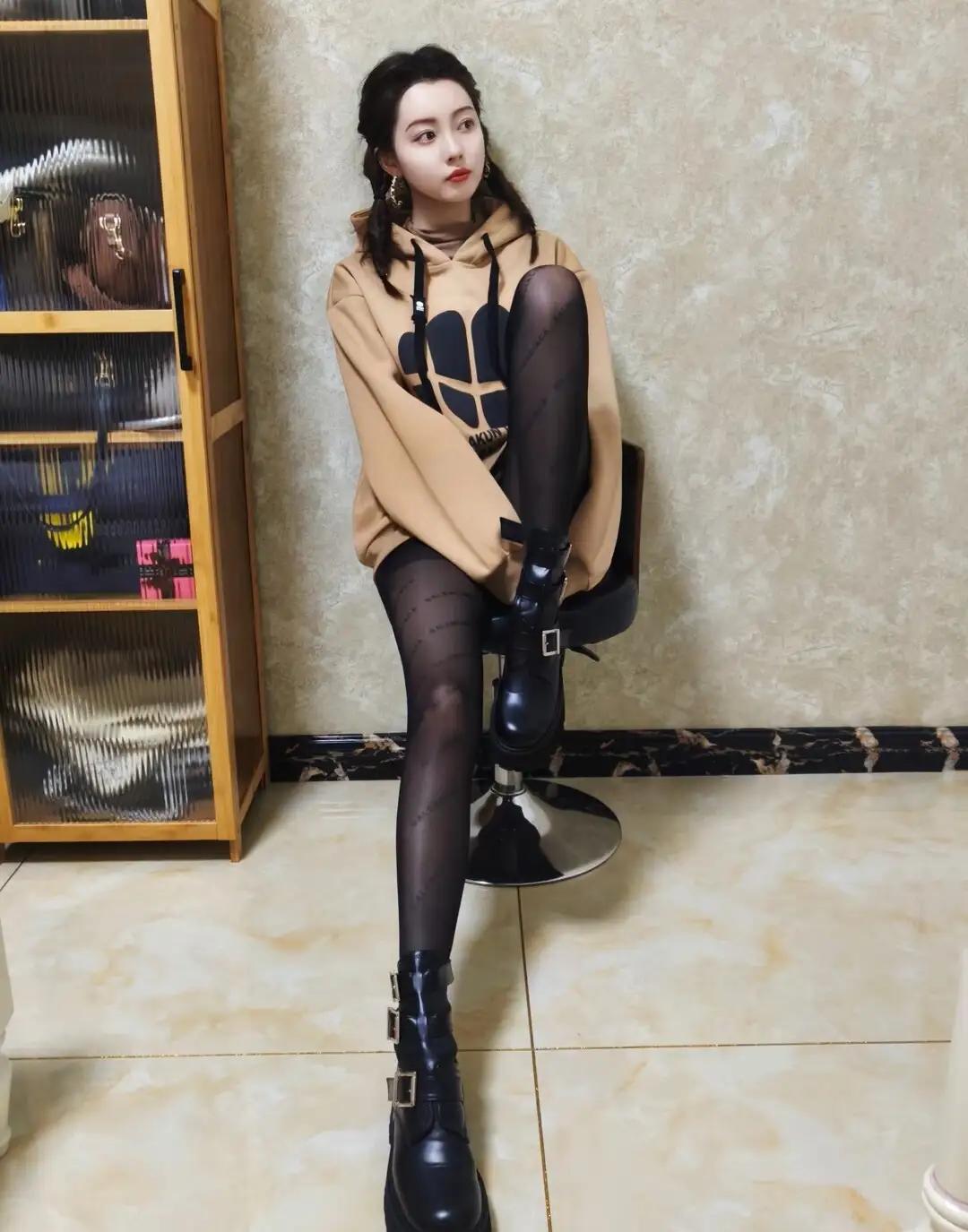 时尚穿搭指南：米色卫衣+黑色丝袜+酷炫靴子，轻松出街！