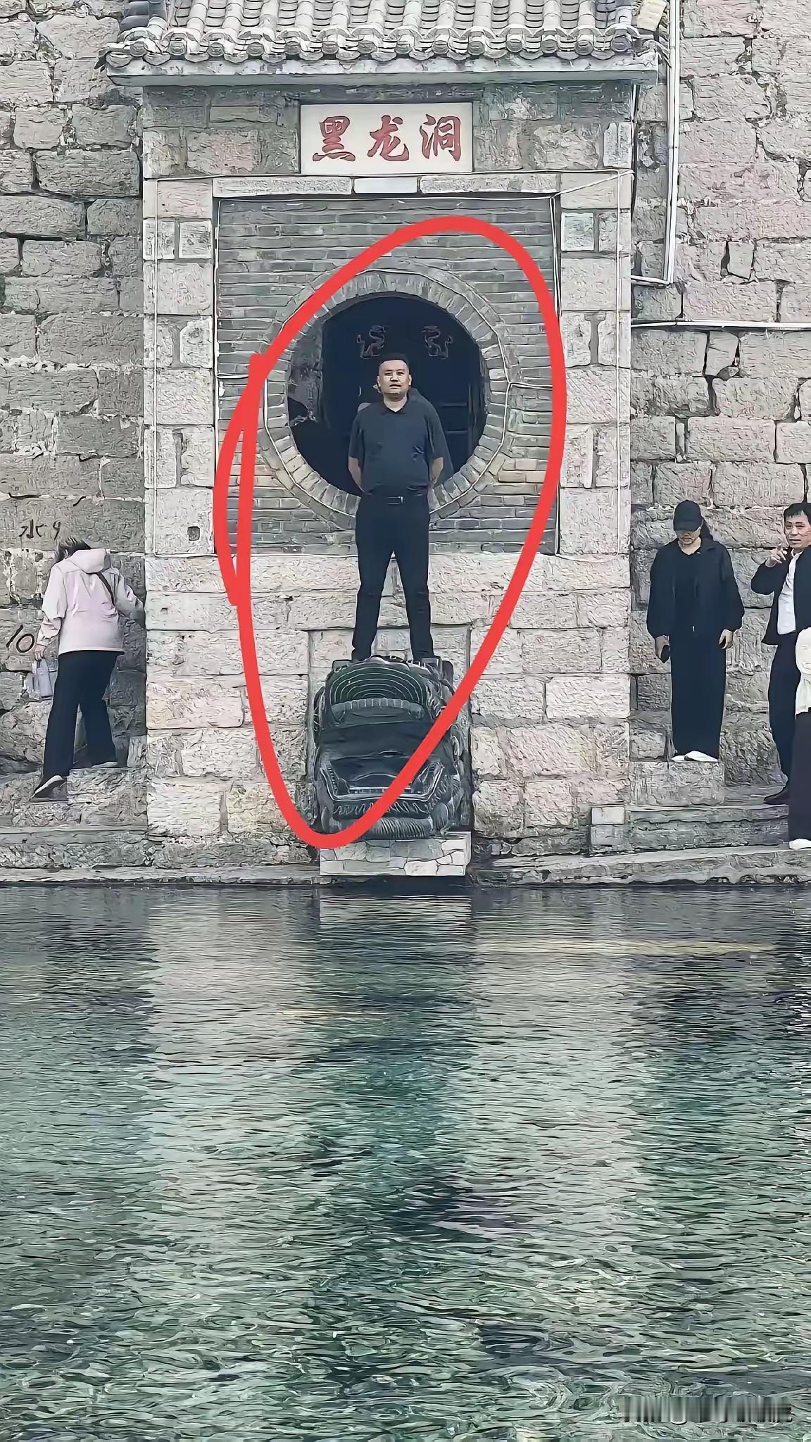 这是一点没有敬畏之心，图中写的是“黑龙洞”这个建筑应该是龙头吧，从个人素质来说公