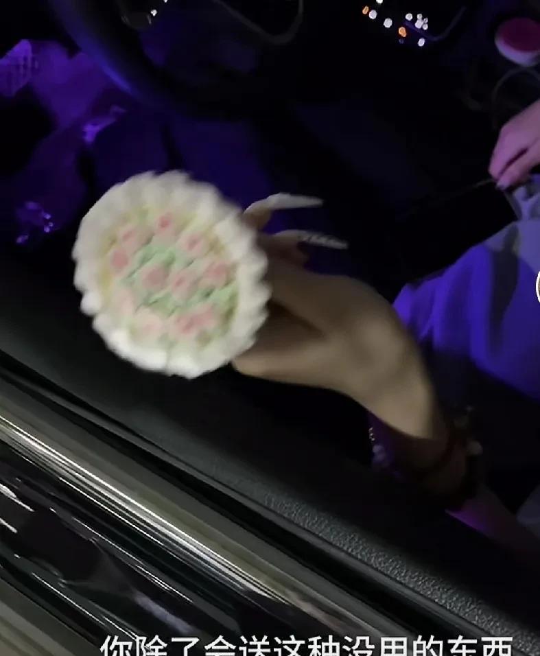 女朋友坐上车后，男孩儿站在外边从车窗递上了自己花费了许久准备的礼物。一支用手钩