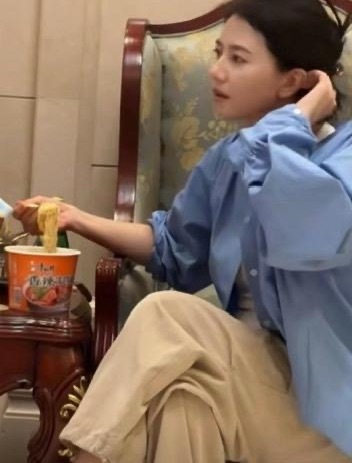 高圆圆机场等飞机，饿得吃泡面，不顾形象。工作人员拍下她叠腿、头发夹起的随意样，一