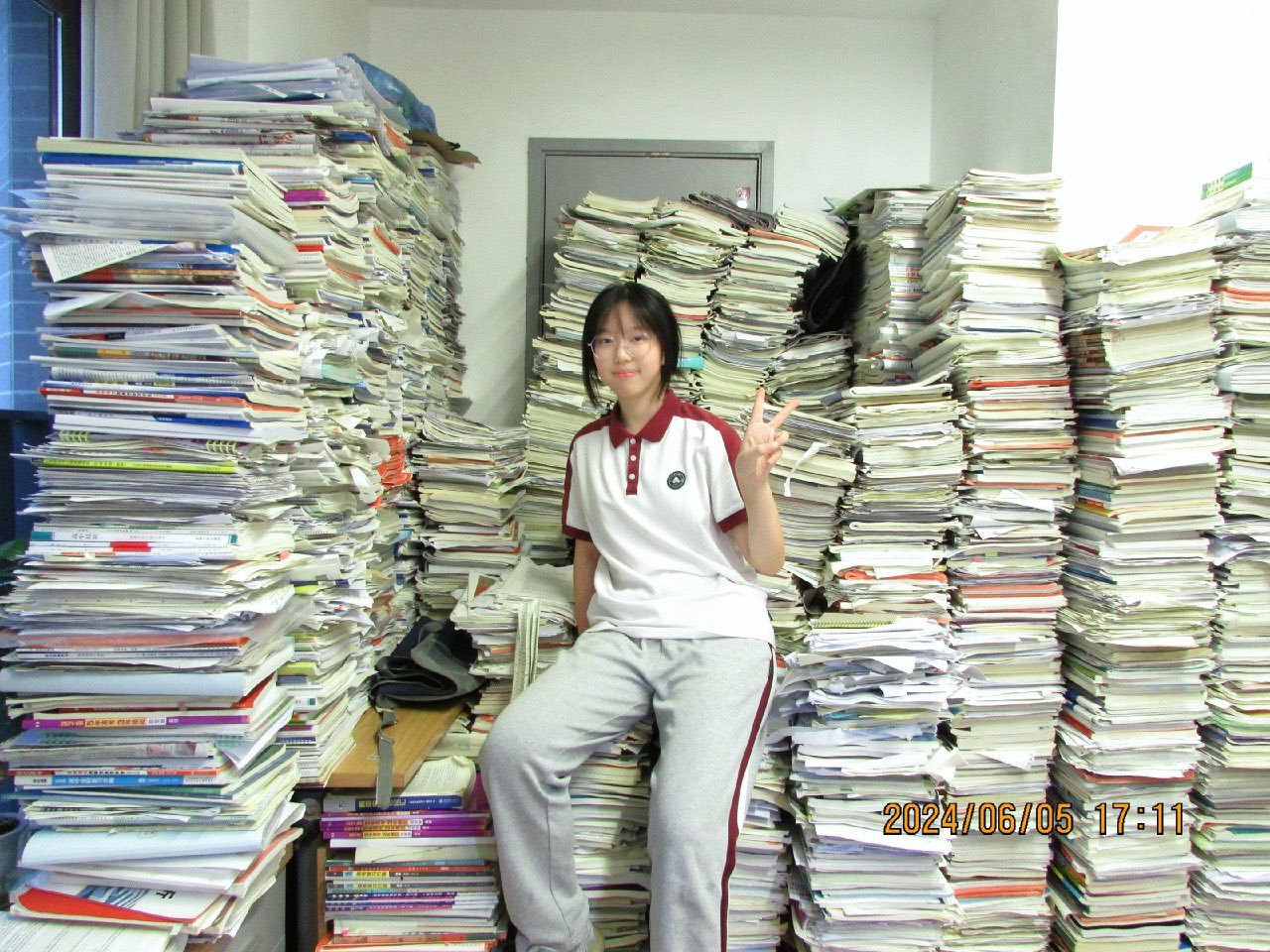 看到一张照片，有个考上大学的孩子，展示她在学校所做过的所有习题资料