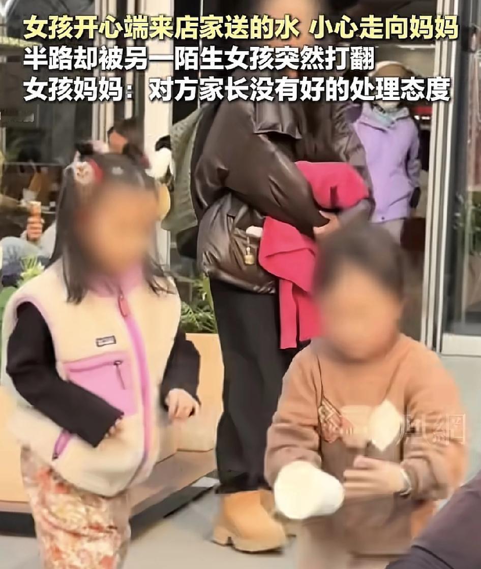 浙江绍兴一商店门口，一名女孩端着店主送过来的热水走向妈妈，跟妈妈说：这是阿姨给我
