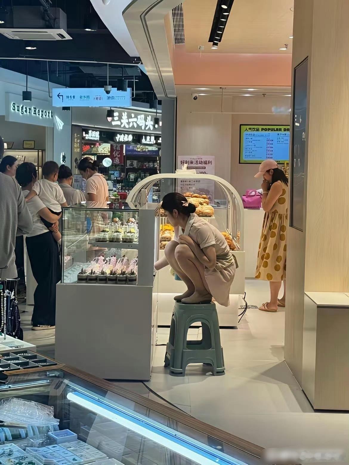 不懂就问好利来为什么一定要踩在凳子上摆蛋糕？