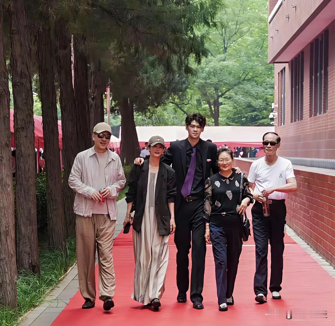 家喻户晓的演员陈建斌一家合影流出，画面里居中身穿黑衣的男孩是他19岁长子。少年身