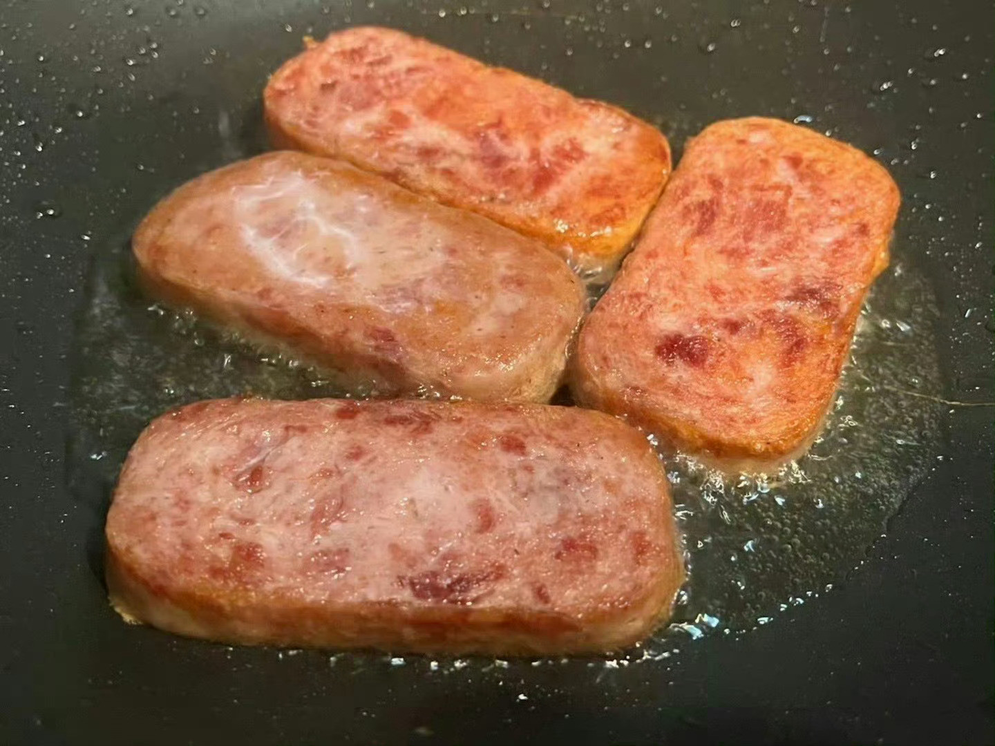 跑步回来，休息会。煎厚切午餐肉，烤馒头。馒头对半开，抹豆腐乳后夹午餐肉。再拌了个
