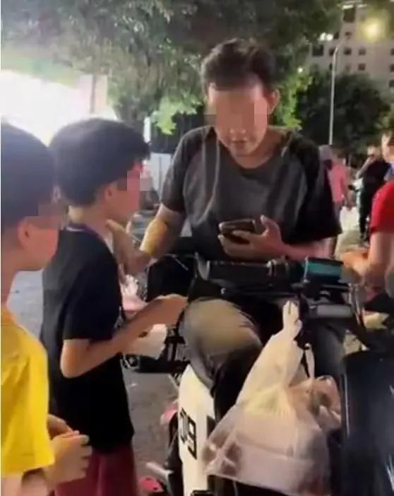 写字楼下，几名十一二岁的小男孩个个脖子上挂着支付码牌子，坐在楼下的绿化带旁边，只