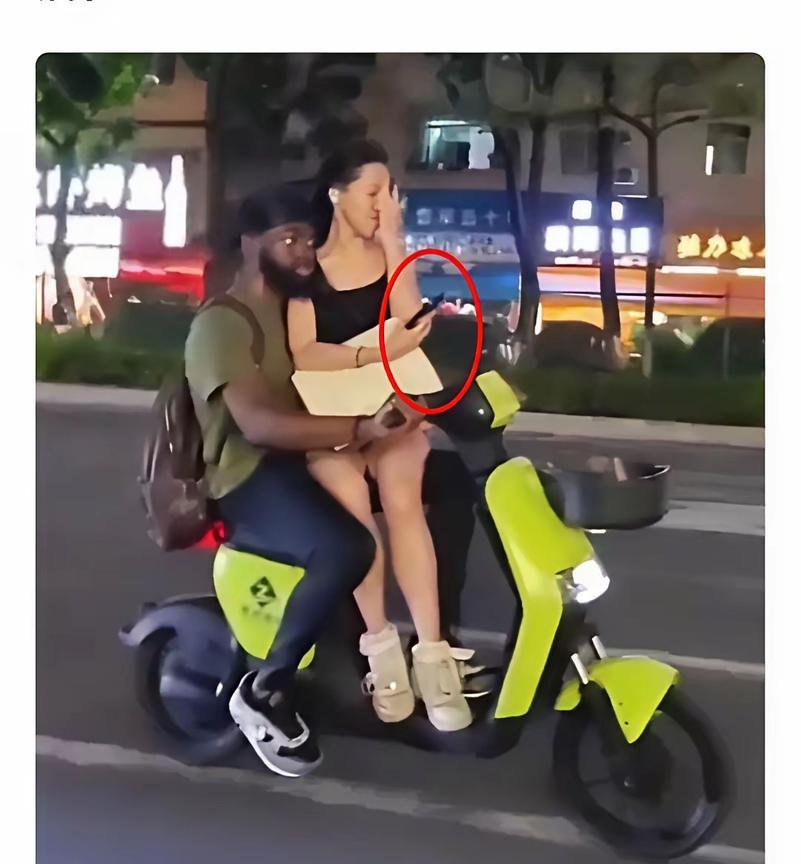 这得有多惬意！怀抱美女，手握单车方向把，黑白分明。来中国的初衷就是这个了吧？网