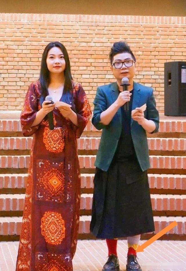 陈青松上身套着西服，下身却配了条黑色长裙，还搭了双大红色的长筒袜，这一身搭配实在