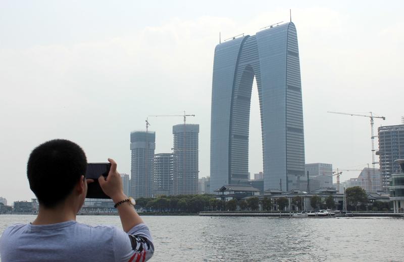 在中国苏州，标志性建筑东方之门傲然矗立。这里是声名远扬的旅游胜地，苏绣、昆曲、评