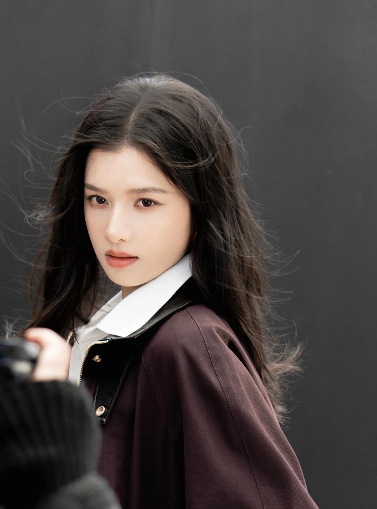#张婧仪#风拂发丝，深棕外套与白衬衫勾勒利落棱角；调整领带的瞬间，又将松弛藏进剪