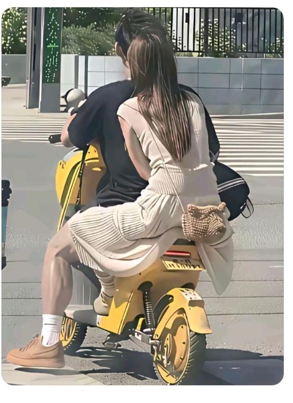 帅哥骑车带美女；一路兜风挺潇洒；可惜安全意识差；开车得戴安全帽；另外美女
