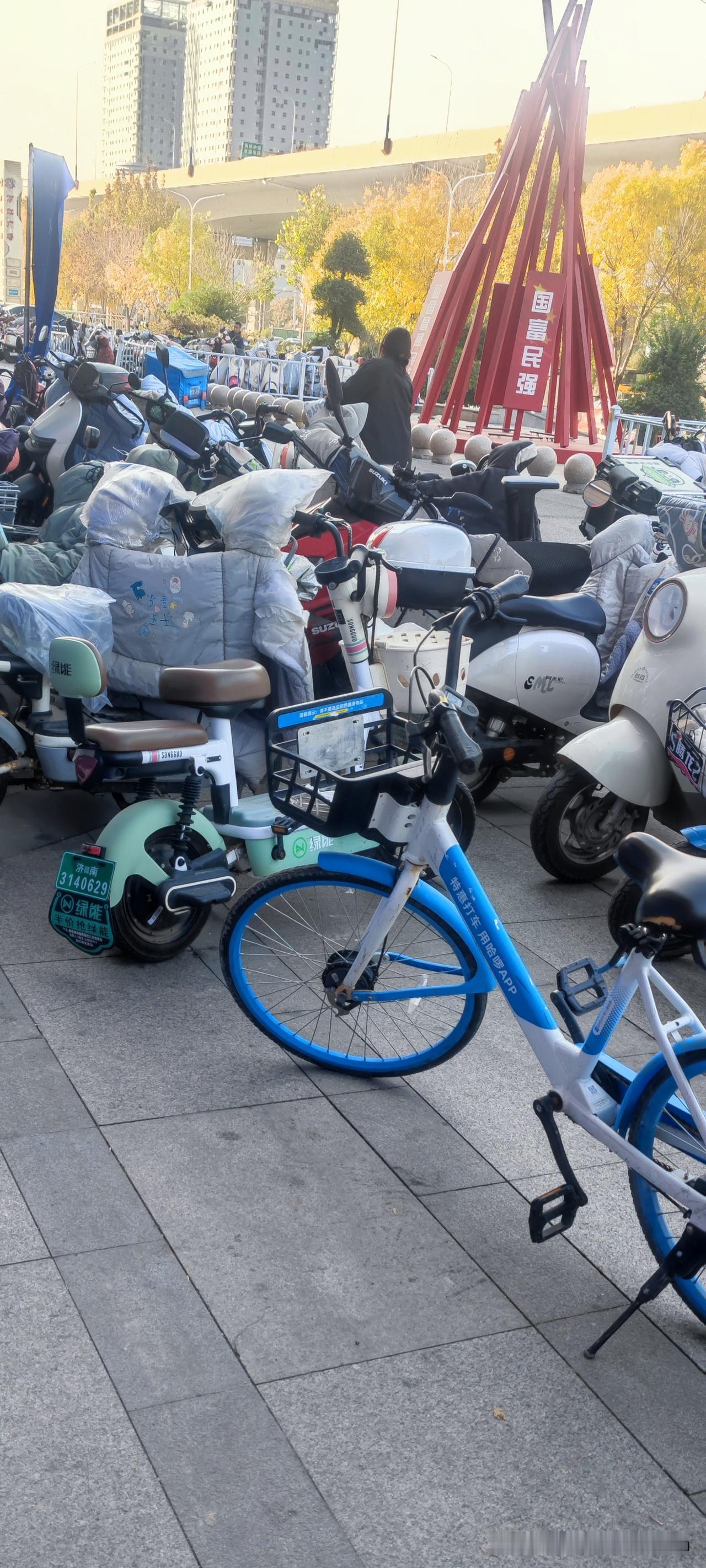 在商场的电动车停车点，所有的电动车自行车都是一排一排的，顺着放的。一个二十
