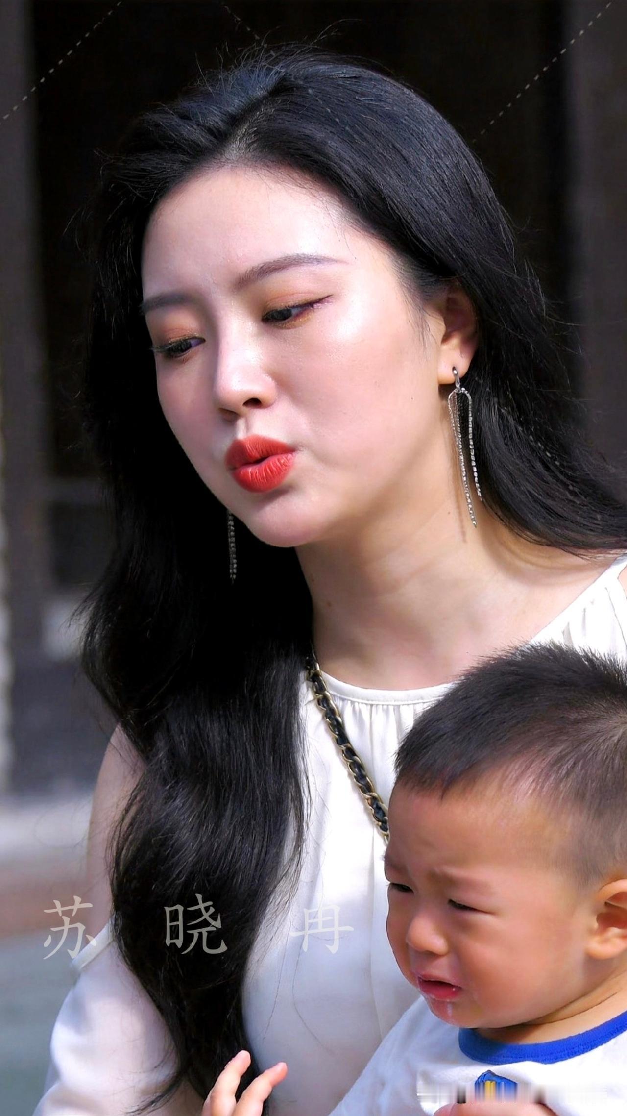 妈妈一把拽住姐姐，提醒她说好不能当着弟弟面吃冰淇淋，小家伙还小吃不了冰。弟