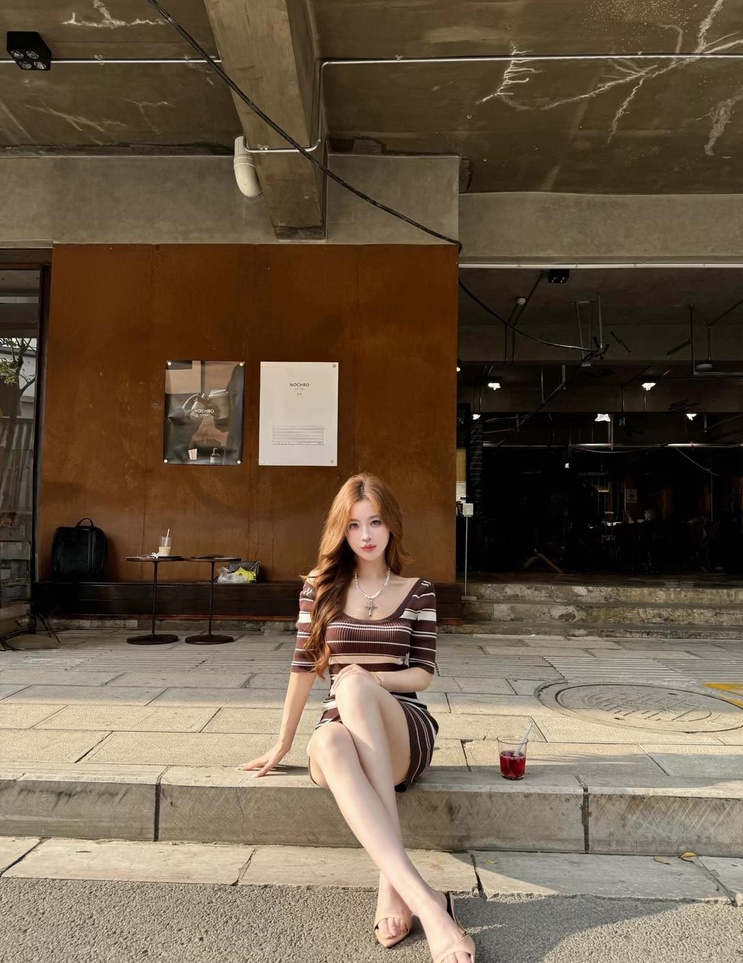 都市咖啡馆的午后时光，红发少女静坐台阶，享受宁静与美好。