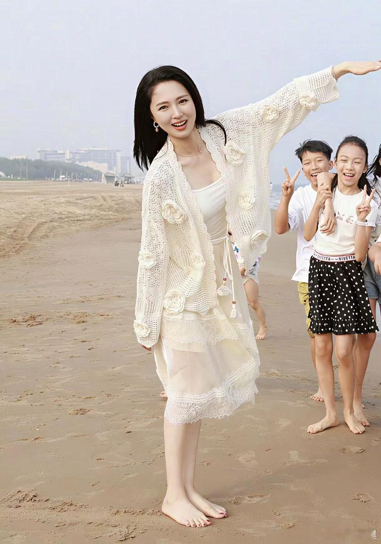 董璇在沙滩光脚出镜氛围感拉满，红色美甲点缀足部，明媚亮眼，整体画面美得让人移不开