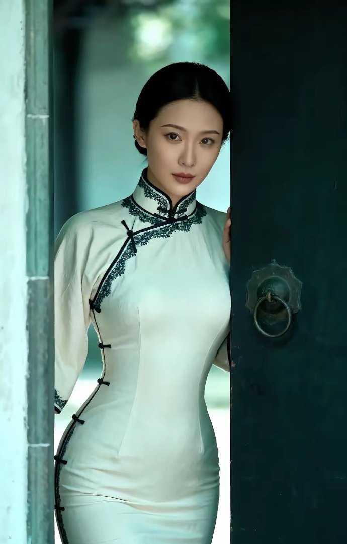 一袭米白旗袍，绣着墨色蕾丝，她立于古门之后，如从民国画卷中走出的佳人，将东方韵致