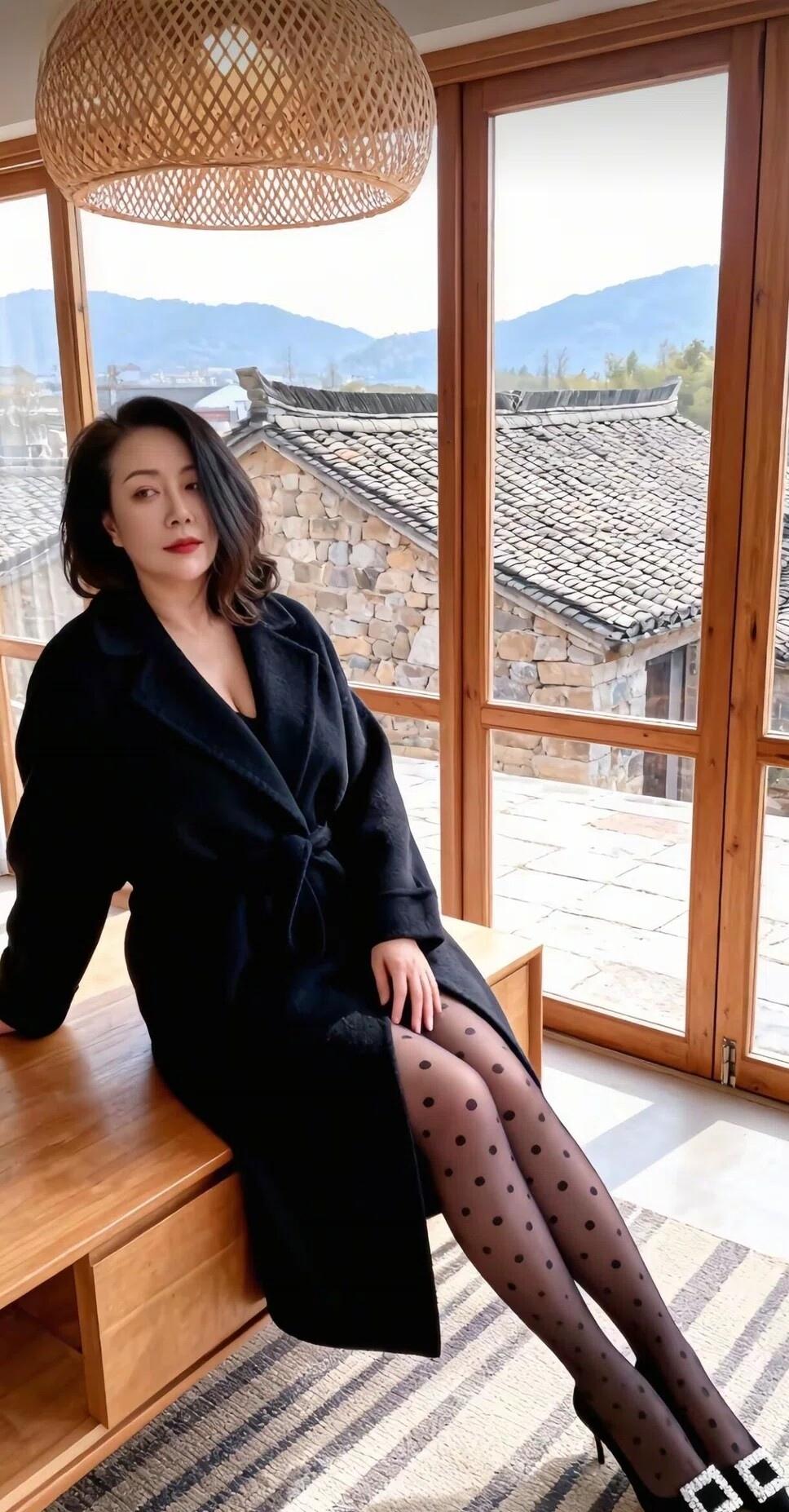 冬日暖阳下的慵懒时光，黑大衣与波点袜的完美搭配，尽显优雅与时尚。
