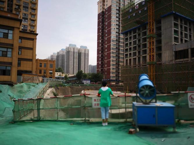 北京，一女子为抄近路从一处施工工地穿过，结果在翻围挡时差点摔跤。但女子并未在意，