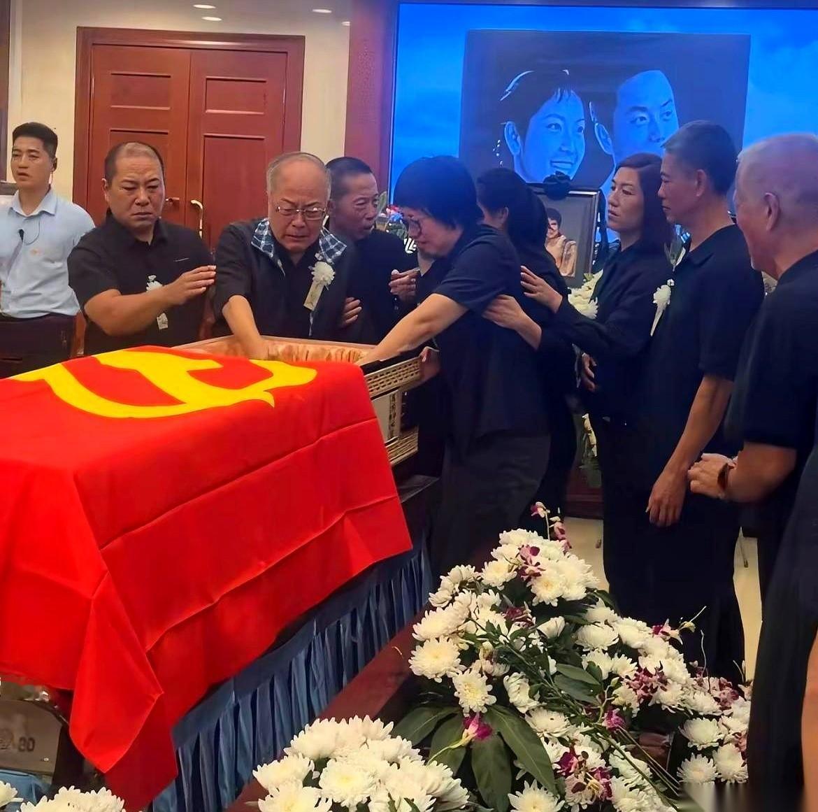 一只布满皱纹的手，颤抖着探进那口覆盖着国旗的棺木。腿脚已经很不好的老头强撑着身