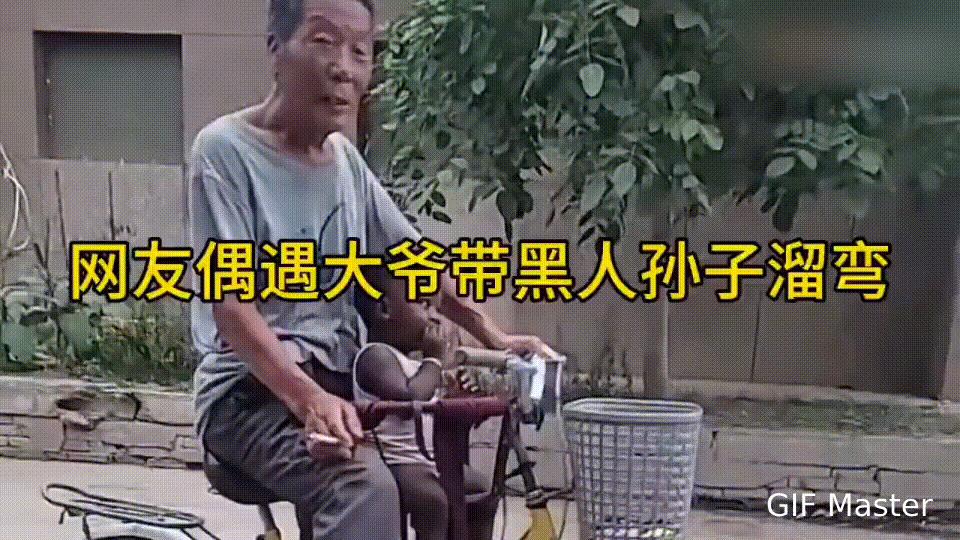 好稀奇！网友在街上看到大爷带着黑人孙子遛弯！这大爷骑着自行车，前面车篮子里坐着个