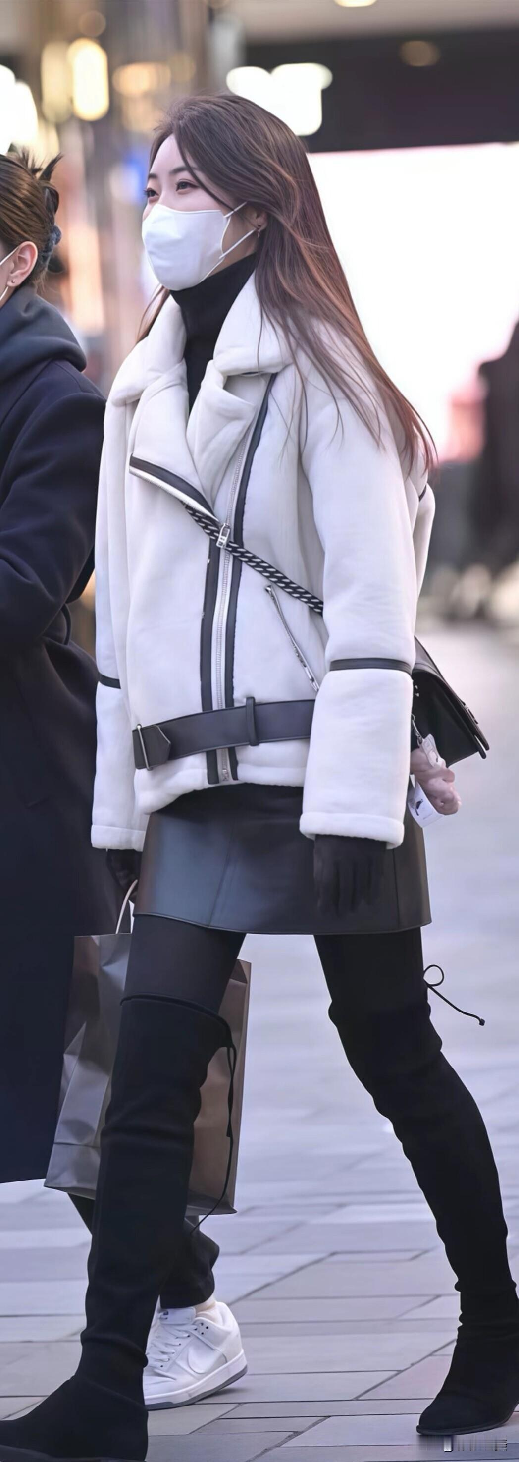 米白色羊羔毛外套配黑色皮裙，搭过膝长靴利落显瘦。冬日经典黑白配，保暖又好看，出门