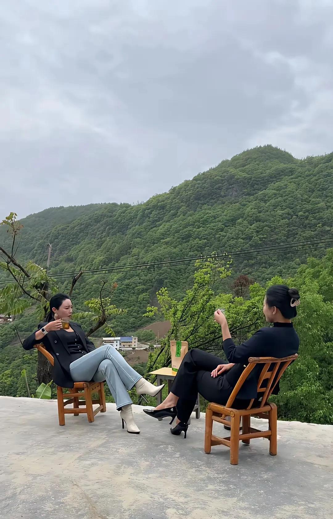 这幅画看着好心情舒畅啊，我能在这个地方品茶看景，真的太美了。两位小姐姐坐在山边的