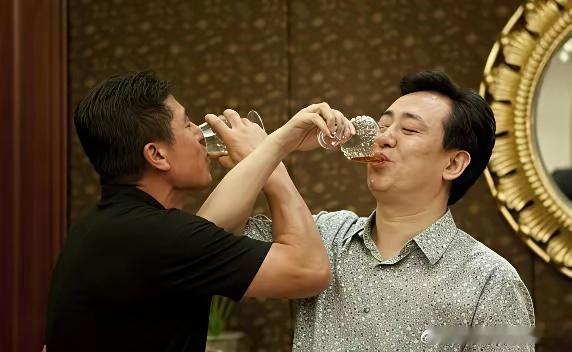 许家印喝酒喝出新花样，他和男子喝交杯酒喝得乐开怀。