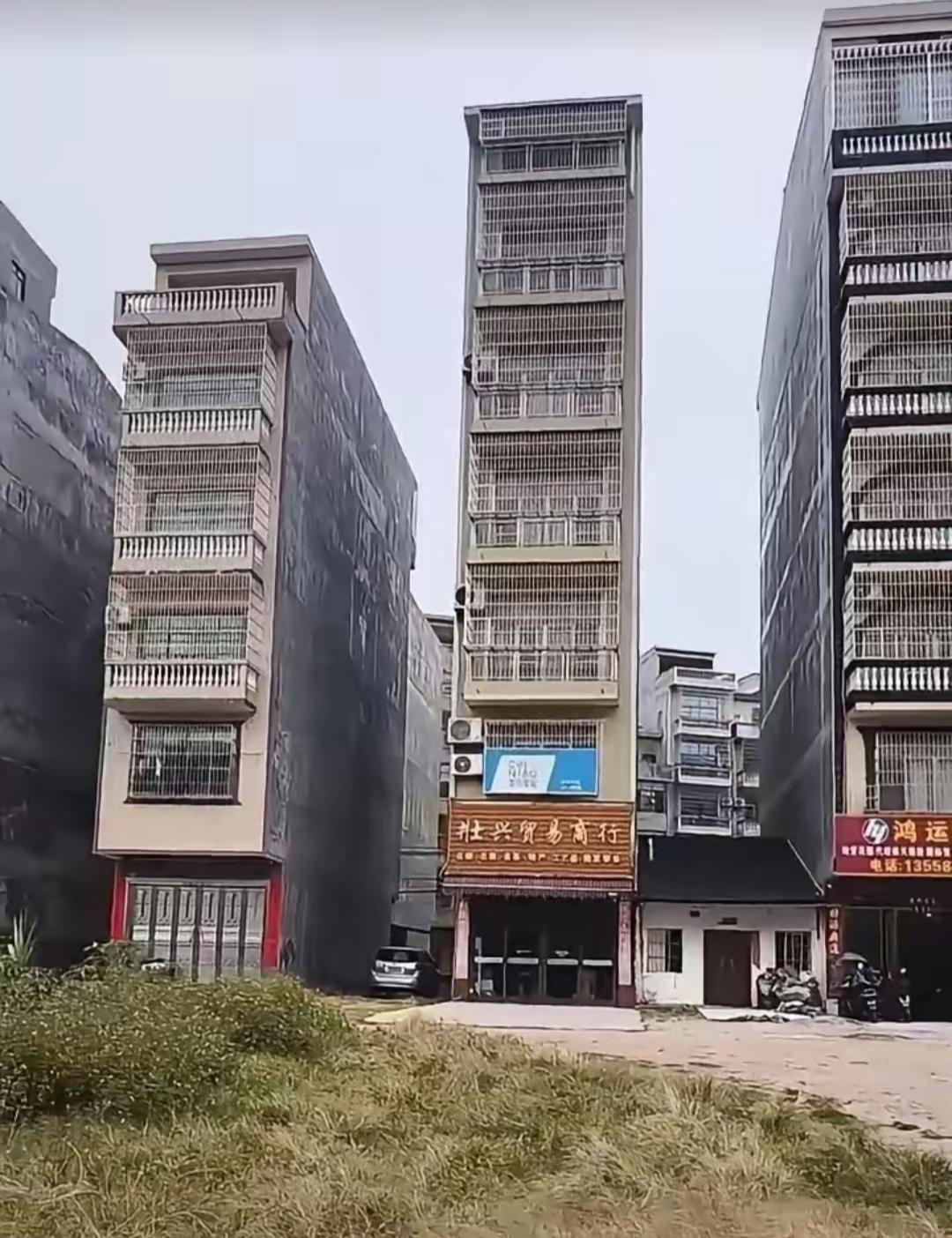 三栋楼房中间夹着个商铺。这楼间距离符合标准吗？半座楼也不见太阳🌞啊，还不如在我