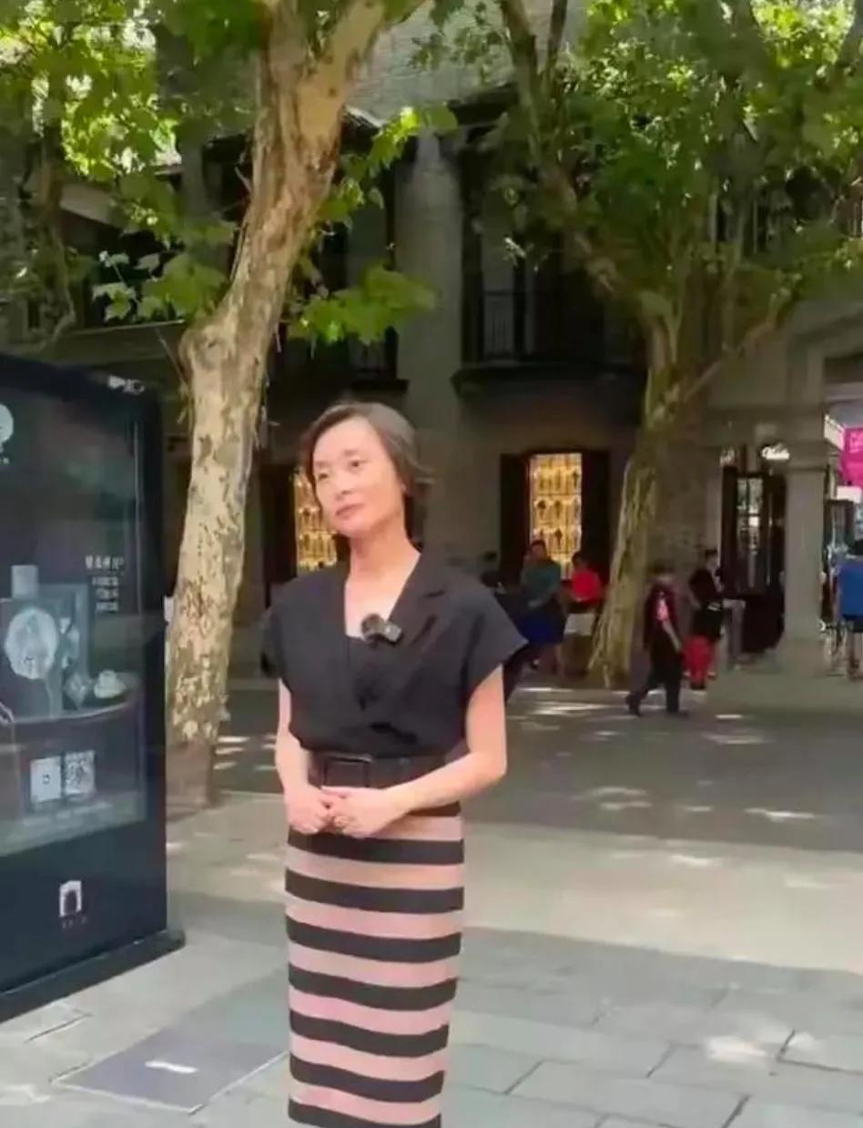 52岁的吴越现身街头，衣着精致，身材正点，发量稀疏，岁月沧桑感明显，但未婚的女人