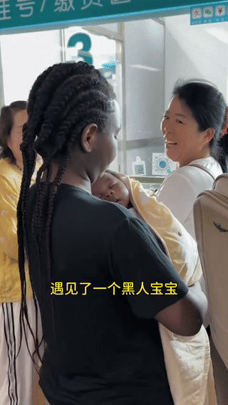 哈尔滨一家医院里。有网友看到一名黑人女子抱着她的孩子正在医院缴费处排队缴费。