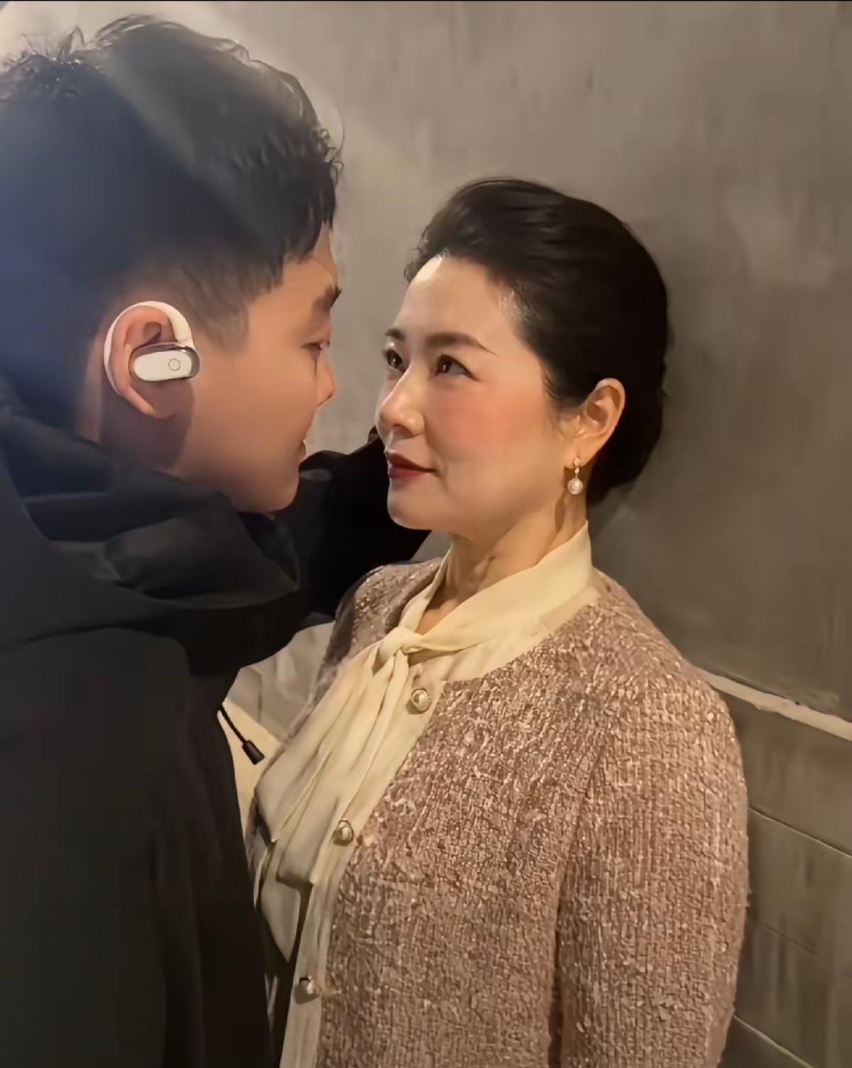 两人靠得很近，似乎在窃窃私语。女的妆容真好看，气质美女。