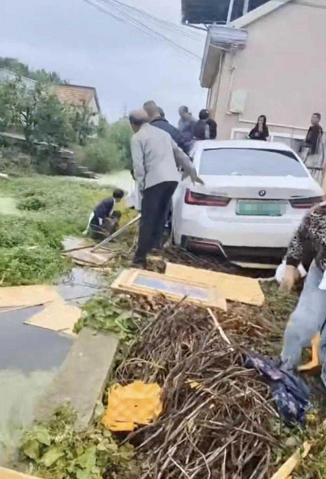 江苏南通，一户村民为离世老人操办丧事，亲友乡邻齐聚门前临时棚内吃席。一辆白色宝马