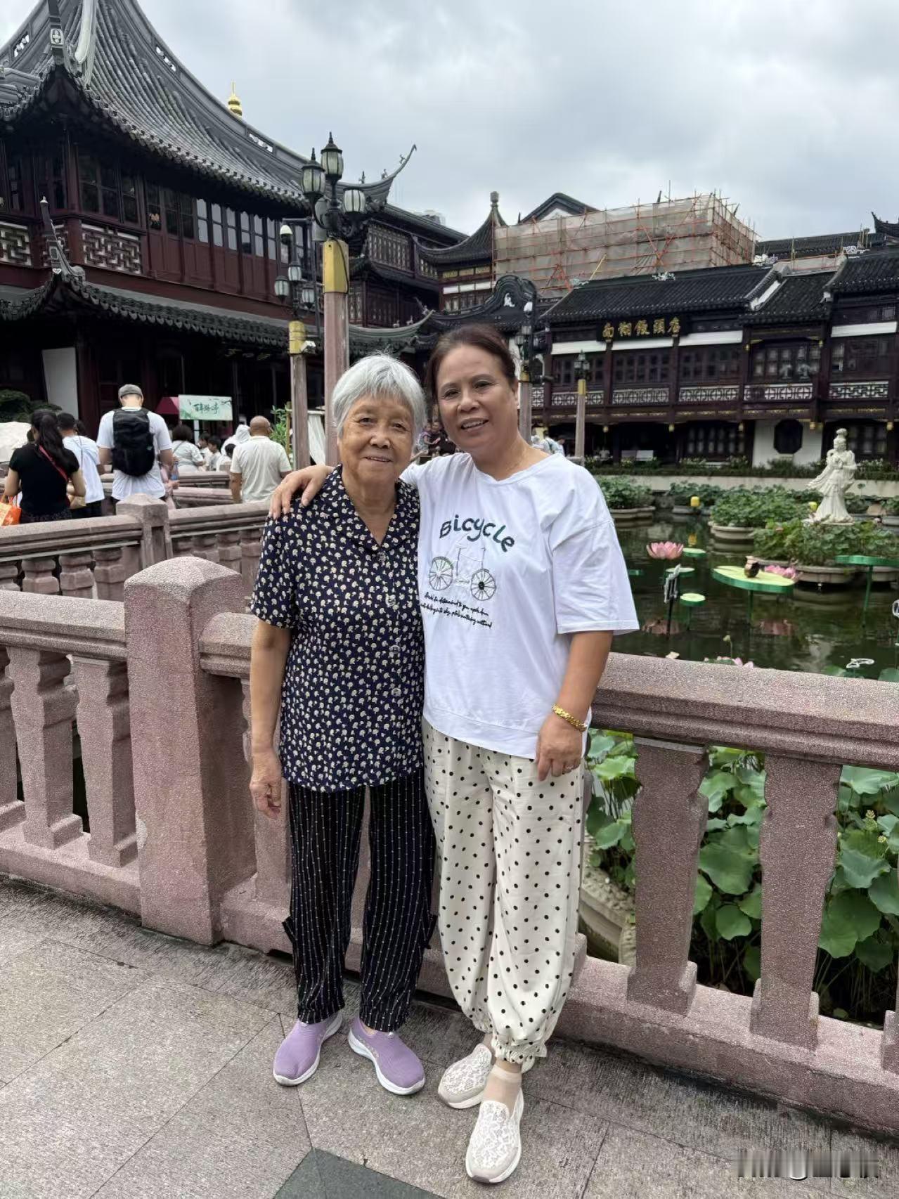 两位女士在古风建筑前合影。