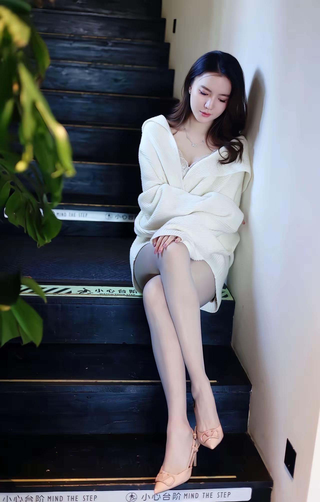 优雅白裙少女，静坐楼梯间，感受时光的静谧。