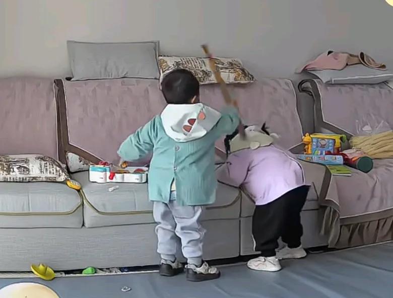 弟弟拿着棍子打姐姐头，奶奶看到后赶忙上前制止，奶奶并拿着小棍帮了弟弟的屁股，弟弟