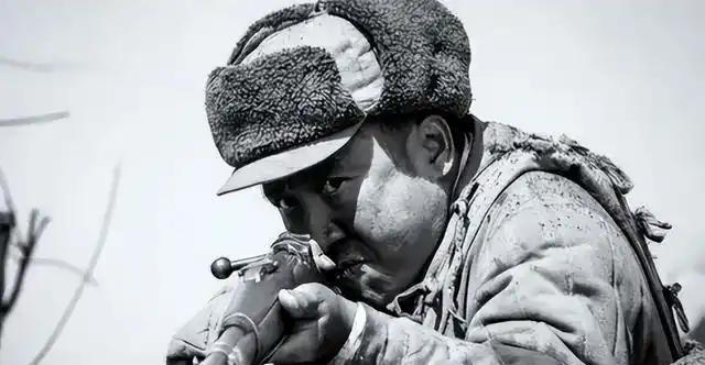 1951年朝鲜战争，一名美国大兵，抽着烟，在看一位牺牲的志愿军战士尸体。这位志愿